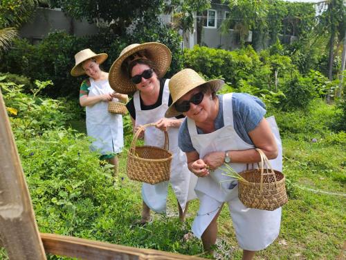 Eine Gruppe von drei Frauen arbeitet in einem Garten in der Unterkunft Phuket Nonnita Boutique Resort - SHA Plus in Phuket