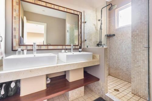 ein Badezimmer mit zwei Waschbecken und einer Dusche in der Unterkunft Peninsula Langosta in Tamarindo