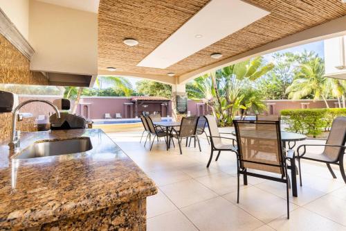 an outdoor kitchen and dining area with tables and chairs at Peninsula Langosta in Tamarindo