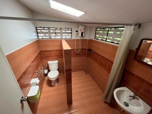 un baño con inodoro y lavabo en บ้านสวนบรรจงอักษร Bansuan Banjong Akkson, en Ban Chek