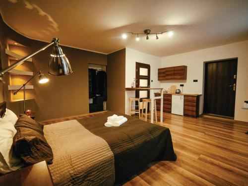 1 Schlafzimmer mit einem großen Bett und einer Küche in der Unterkunft Apartament Focha 26 in Bydgoszcz