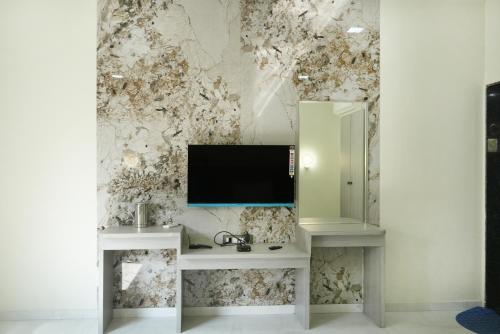 Habitación con TV en la pared en hotel rajwada, en Bhuj