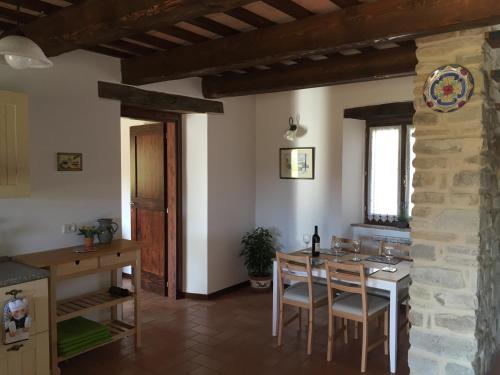 cocina y comedor con mesa y sillas en Casa Edera, en Montelparo