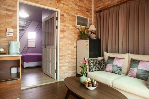 a living room with a couch and a table at Palm Sweet Hotel in Sathani Rot Fai