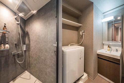 a bathroom with a shower and a washing machine at Apartment Hotel 11 Nambaminami 2 in Osaka