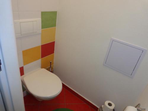 a bathroom with a toilet and a colorful wall at Jasna 96 II in Belá