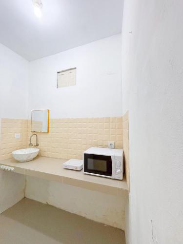 eine Mikrowelle auf einer Theke mit Spüle in der Unterkunft Yan Loft in Uluwatu