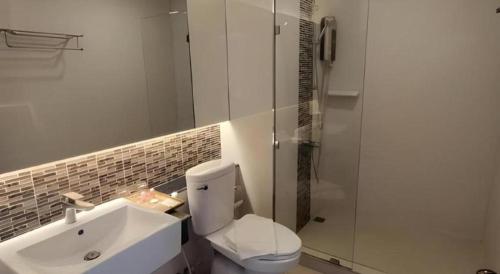 a bathroom with a toilet and a sink and a shower at Chaisaeng Villa in Sing Buri