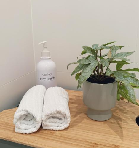 - une table en bois avec des serviettes et une bouteille de savon dans l'établissement Suites am Herzogberg, à Brunn am Gebirge