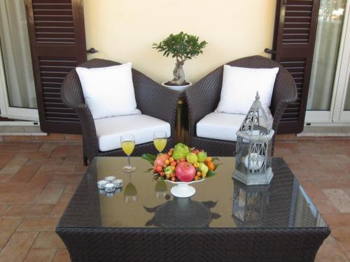 a coffee table with a bowl of fruit and two chairs at Dea Suite Roma in Rome