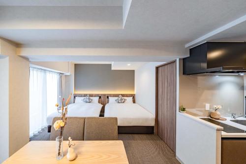 a hotel room with a bed and a kitchen at Apartment Hotel 11 Nambaminami 2 in Osaka
