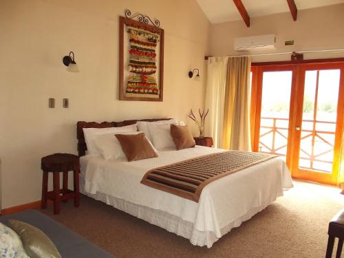 a bedroom with a large bed and a window at Eco Hotel Antuco in Antuco