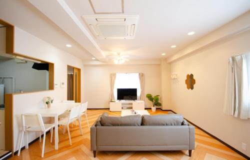 a living room with a couch and a table at Sakura Coco Residence in Osaka