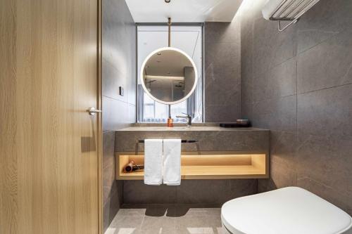 un bagno con lavandino, WC e specchio di Orange Hotel Shanghai Meilong Wanhui International Plaza a Shanghai