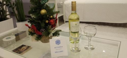 a bottle of wine and a glass on a table at ''Aetheria'' Rooftop Resort with sea view in Kremasti
