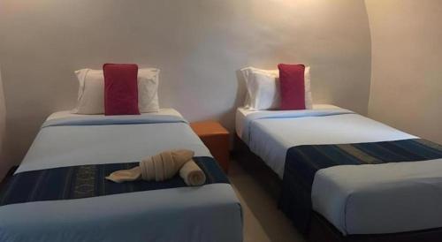 a room with two twin beds with red pillows at Eskimo Resort in Ban Pa Kruat