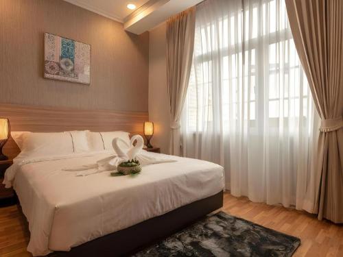 a bedroom with a large bed with a flower on it at One Vientiane Hotel in Vientiane