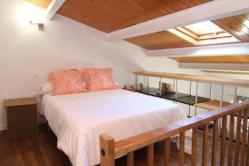 um quarto com uma cama num quarto com tectos em madeira em PINTORES ROOMS Apartamentos Turísticos em Cáceres