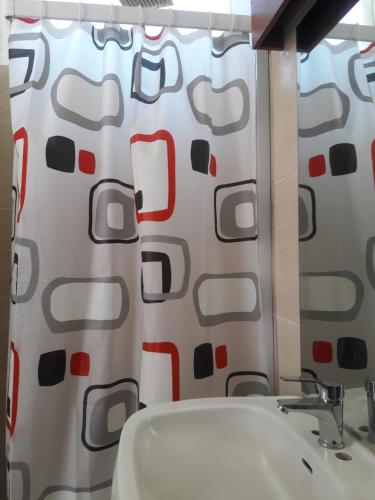 a bathroom with a shower curtain with a sink at Onkel Inn Wagon Sleepbox Uyuni in Uyuni