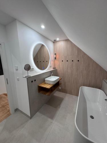 une salle de bain avec un lavabo, une baignoire et un miroir dans l'établissement Möbliertes Familienhaus in Hamburg, à Niederdorla