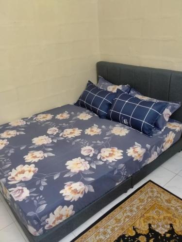 un lit avec une couette bleue et des oreillers dessus dans l'établissement D Baity Homestay Gemas-MALAY ONLY, à Gemas