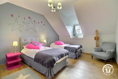 吉代勒La mesange bleue的配有粉红色枕头和椅子的客房内的两张床