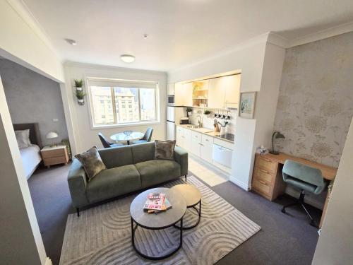 a living room with a couch and a table at Luxury CBD Penthouse Studio - Paris End of Collins St - Location Location Location in Melbourne