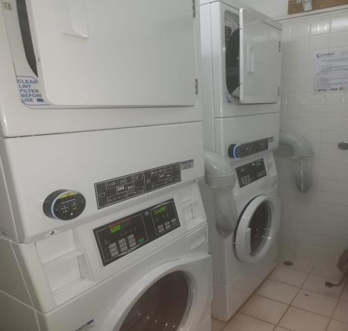 a washing machine and a washer and dryer in a bathroom at Luxury CBD Penthouse Studio - Paris End of Collins St - Location Location Location in Melbourne