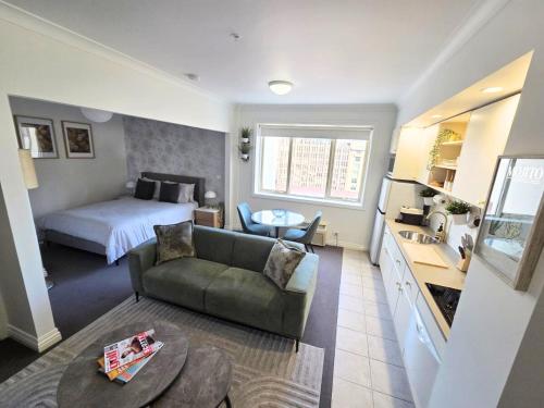 a small living room with a bed and a couch at Luxury CBD Penthouse Studio - Paris End of Collins St - Location Location Location in Melbourne
