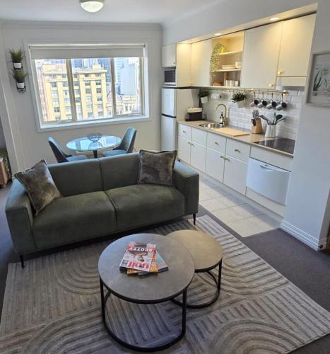 a living room with a couch and a table at Luxury CBD Penthouse Studio - Paris End of Collins St - Location Location Location in Melbourne