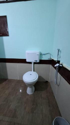 a bathroom with a white toilet in a room at Mitali Homestay in Dibrugarh