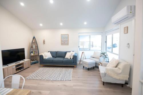 a living room with a couch and a tv at The Basin Nest, a peaceful home at St Georges Basin in St Georges Basin