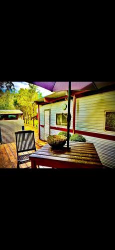 a table with an umbrella and a chair on a patio at Rancho Relaxo in Blackwood
