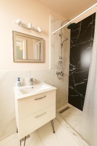 a bathroom with a sink and a shower at ZiAna - Hiperbara Livezeni in Livezeni