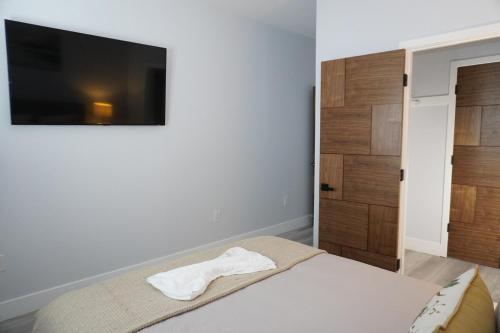 ein Schlafzimmer mit einem Bett und einem Flachbildfernseher in der Unterkunft Near Disneyland and Huntington Beach, Little Saigon in Garden Grove