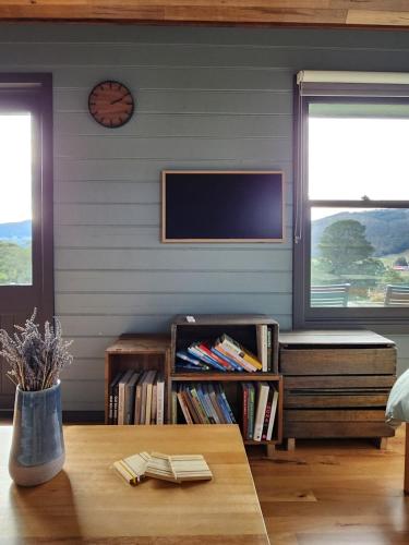 a living room with a tv and a table at Romantic Valley Cabin - Outdoor Bath in Glen Huon