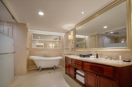 a bathroom with a tub and a sink and mirror at Kempinski Hotel Guiyang in Guiyang