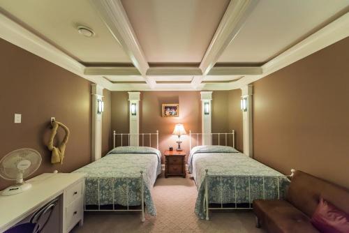 Grace Guest House في وايت روك: غرفة نوم بسريرين وطاولة بها مصباح