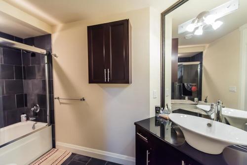uma casa de banho com 2 lavatórios, uma banheira e um espelho. em Grace Guest House em White Rock