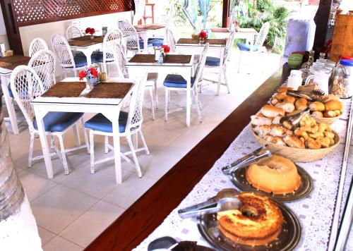 a table with plates of food and tables and chairs at Hotel e Pousada La Dolce Vita in Canoa Quebrada
