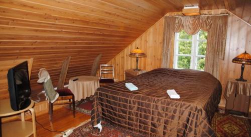 a bedroom with a bed in a log cabin at Hotelli Luostarin Puutarha in Naantali