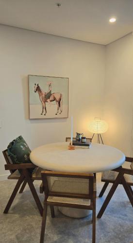 a table in a room with a picture of a horse at Rivi Retreat - Brand New Luxury & Central in Sydney