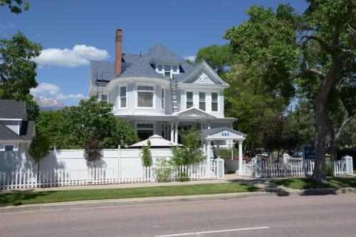 una cerca blanca frente a una casa blanca en The St. Mary's Inn, Bed and Breakfast, en Colorado Springs