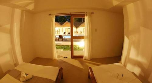 Zimmer mit 2 Betten und einer offenen Tür in der Unterkunft Elysia Beach Resort in Donsol