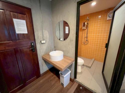 a bathroom with a sink and a toilet and a mirror at Wat We See Bangkok Hostel in Bangkok