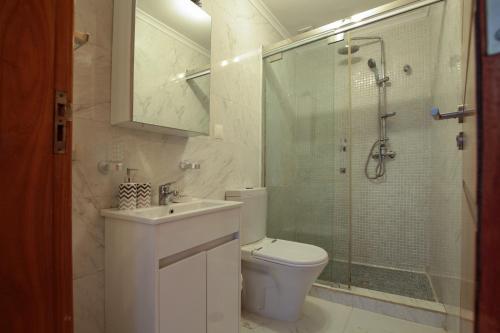 ein Badezimmer mit Toilette und Glasdusche in der Unterkunft Josden Maianga T2 in Luanda