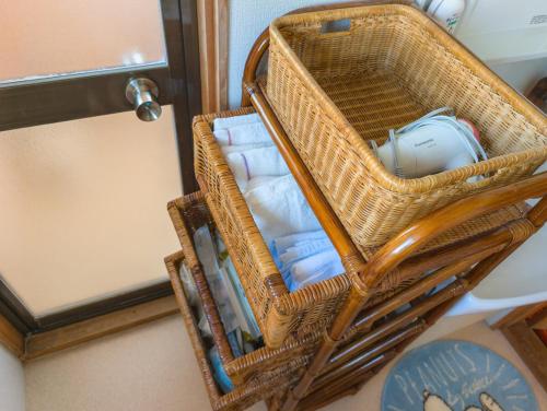 - un panier en osier avec des serviettes dans la chambre dans l'établissement ゲストハウス634庵, à Sango