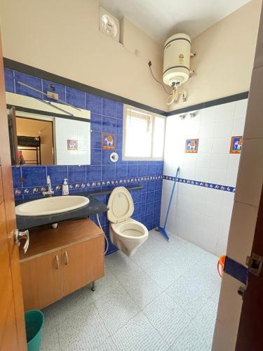 a blue bathroom with a toilet and a sink at Neha's Homestay in Mysore