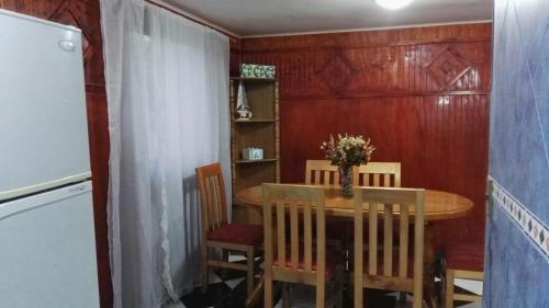 a dining room with a table and chairs and a refrigerator at Parques de Afunalhue in Licán Ray