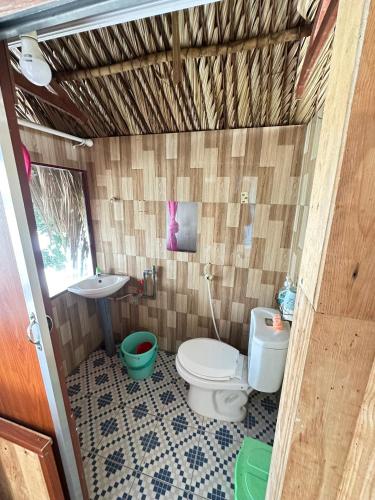 a bathroom with a toilet and a sink at Người Giữ Rừng- Nhà hàng và Du Lịch Sinh Thái in Bình Ðại